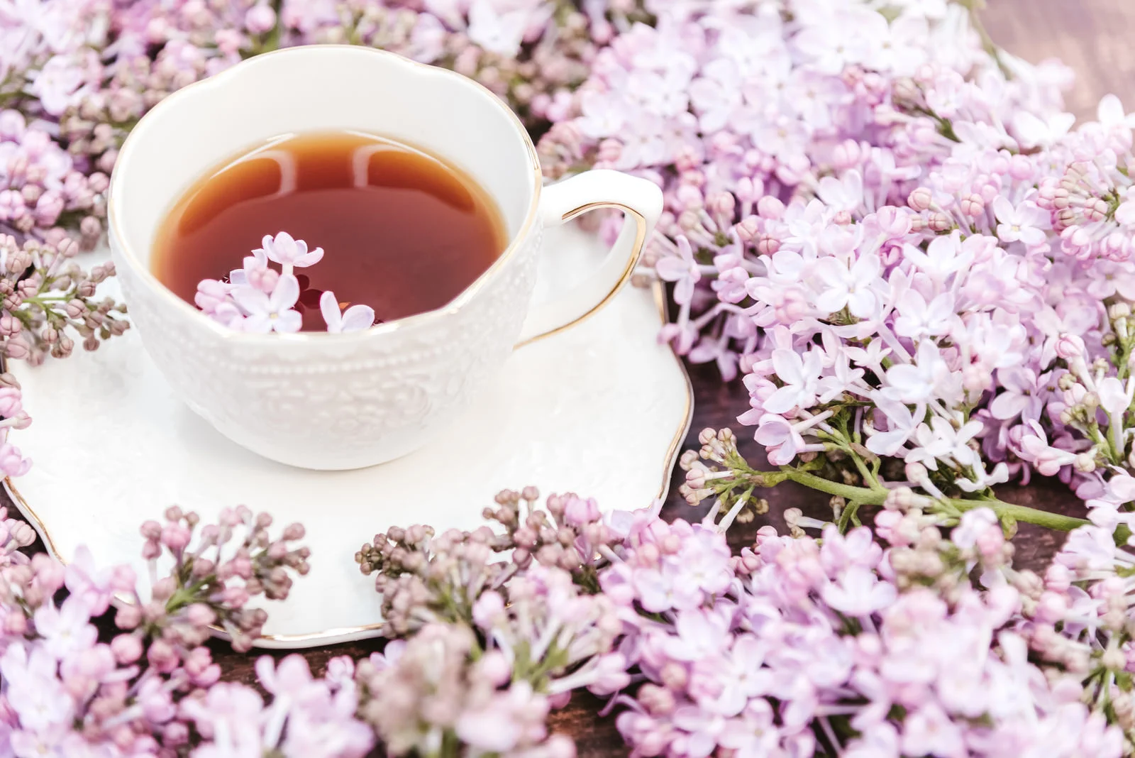 紅茶のティーカップの周りに、ピンクの花